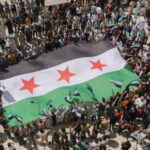 Demonstrators hold the Syrian opposition flag as they gather during a protest against Arab normalization with Syria's President Bashar al-Assad and the Arab League's reintegration of Syria, in the rebel-held city of Azaz, Syria May 19, 2023. REUTERS/Khalil Ashawi