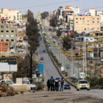People stand along the side of a road as vehicles move past in Syria's southern city of Sweida on December 29, 2024. (Photo by Bakr ALKASEM / AFP) (Photo by BAKR ALKASEM/AFP via Getty Images)
